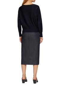 Navy knitted sweater with ribbed hem paired with a knee-length dark denim skirt. The ensemble features a simple, fitted design.