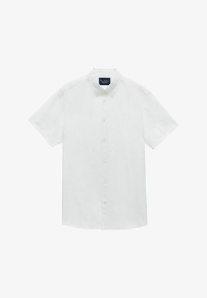 Chemise blanche à manches courtes en coton. Elle présente un col classique, une patte de boutonnage sur le devant et une poche poitrine simple.