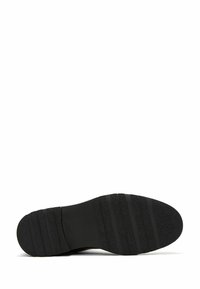 Suola di scarpa nera con texture rigata; centro liscio e bordi testurizzati, per garantire aderenza. Presenta scanalature orizzontali per flessibilità.