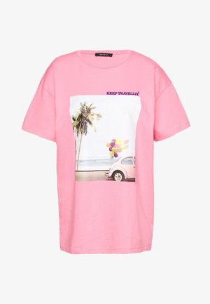 Roze katoenen T-shirt met een afbeelding van palmbomen en een vintage auto met ballonnen, met daarboven de tekst "KEEP TRAVELLIN’".