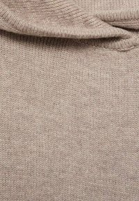 Bežna pletenina, ki prikazuje mehak otip z rebrastim vzorcem in učinkom ovitega ovratnika. Material deluje topel in lahek.