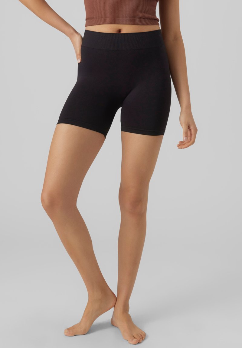 Svarte shorts laget av elastisk stoff, med en bred elastisk linning. Shortsene har en tettsittende design og når midt på låret.