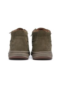 Zapatos de ante verde de caña alta con un acabado texturizado, que cuentan con soporte acolchado en el tobillo y una suela de goma. Detalle sutil del logo cerca del talón.