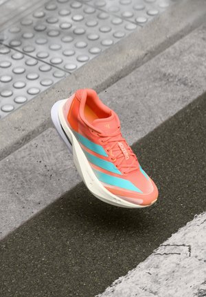Lightweight running shoe in vibrant coral with aqua stripes. Made of mesh upper and rubber sole, featuring a cushioned heel for comfort.