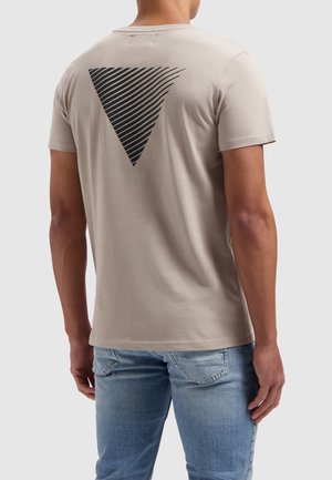 Lichtbeige T-shirt met een zwart gestreept driehoekdesign op de achterkant. Korte mouwen, ronde hals en gemaakt van zacht katoen.