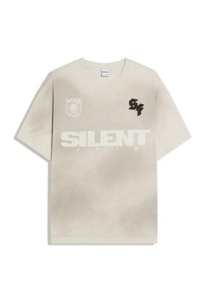 T-shirt beige à manches courtes avec le texte "SILENT", petit graphique noir "S4" sur la poitrine droite, et emblème blanc avec un lion sur la poitrine gauche.