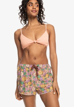 Haut de bikini rose clair à côtes avec un nœud à l'avant. Shorts à imprimé floral multicolore avec taille élastique à cordon de serrage et ourlet effiloché.