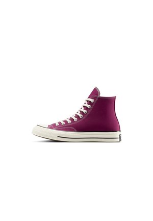 Lila Canvas-Sneaker mit hohem Schaft, weißen Schnürsenkeln und Gummisohle, von der Seite auf weißem Hintergrund betrachtet.