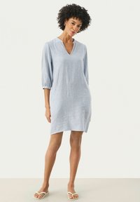 Robe rayée bleue avec un décolleté en V, des manches trois-quarts et une coupe décontractée. Fabriquée en tissu léger, atteignant le milieu de la cuisse.