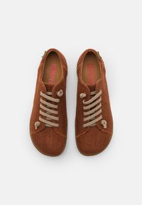 Scarpe in maglia marrone con lacci beige, punta arrotondata e superficie testurizzata. Logo "Camper" in rosa sulla soletta.