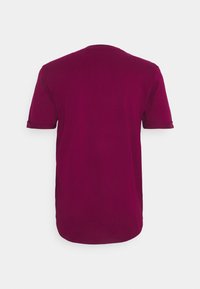 Koszulka z krótkim rękawem w głębokim bordo, z okrągłym dekoltem, wykonana z miękkiej bawełny, z podwiniętymi mankietami i zaokrąglonym dołem.