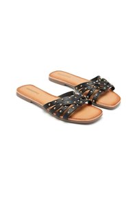 Sandales noires avec des brides entrecroisées ornées de clous dorés, semelle plate et semelle intérieure lisse marron, conçues pour un enfilage facile.