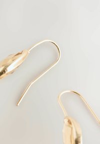Zlatne naušnice s dizajnom fasetiranog lista i dugim kukicama. Glatka površina, minimalistički oblik i elegantan sjaj.