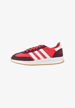 Chaussures de sport rouges et bordeaux avec des rayures blanches, un dessus en suède et synthétique, une semelle rembourrée et une semelle extérieure en caoutchouc texturé.