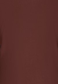 Weinrotes Oberteil mit glatter Textur, das ein schlichtes Design aufweist und keine sichtbaren Muster oder Hardwaredetails hat.
