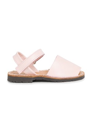 Sandailles en cuir rose clair avec un bout ouvert, des lanières diagonales et une semelle en caoutchouc plate. Couture renforcée visible le long des bords.