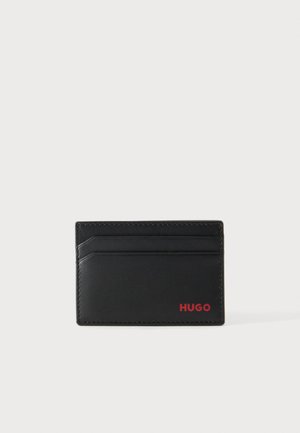 Black leather cardholder with two card slots and red "HUGO" logo in the bottom right corner on a plain background.