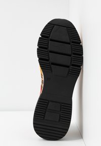 Flerfärgad skosula med djupa mönster, svart gummimaterial, med ett texturerat mönster och storlek markerad som 37.