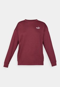 Maronfarvet sweatshirts med lange ærmer, rund hals og ribbede manchetter. Har et hvidt logo på brystet. Fremstillet af blødt, struktureret stof.