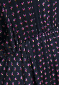 Svart tyg med ett upprepat mönster av rosa och gula rundade former. Vidd i midjan, slät textur, lätt material.