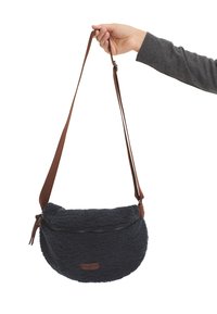 Borsa a tracolla blu navy, con una texture morbida e una forma arrotondata, dotata di una tracolla regolabile marrone e di una chiusura superiore con zip.