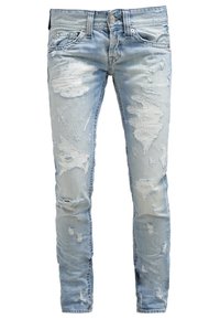 Jeans de mezclilla azul claro con parches desgastados y detalles rasgados. Diseño ajustado con cinco bolsillos y cierre de botón. Textura usada.