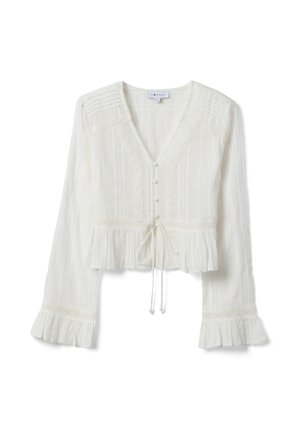 Blouse blanche à manches longues avec col en V, boutonnée sur le devant, ceinture à la taille, plis pincés sur les épaules, et volants aux poignets et à l'ourlet.