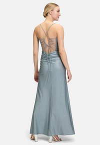 Robe de soirée longue, scintillante, argentée-bleue avec un corsage ajusté, dos transparent et détails de lien ajustables. Longueur au sol avec un léger évasement.