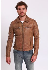 Braune Lederjacke mit Kragen, Reißverschluss und zwei Brusttaschen. Die strukturierte Oberfläche und das taillierte Design ergänzen die blauen Jeans.
