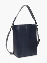 Bolso tipo bucket de cuero azul marino con dos correas ajustables, acabado suave, costuras verticales y diseño minimalista sobre fondo blanco.