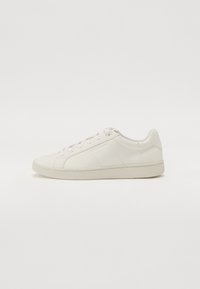 Sneaker bianco in pelle con texture liscia, punta tondeggiante, tradizionale chiusura con lacci e suola in gomma a profilo basso. Design minimalista.