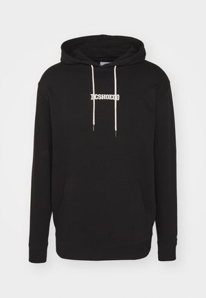 Black hoodie made of cotton. Features a front pouch pocket, drawstrings with cream accents, and “DCSHOECO” logo in white embroidery.