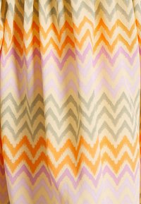 Hedvábí světlé béžové barvy se vzorem cik-cak ve své syté oranžové, levandulové, šedé a žluté barvě. Hladká textura s jemným, volným skladem.