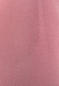 Tela de color rosa claro con una textura suave que presenta patrones sutiles. El material parece elástico y está en primer plano, mostrando detalles y el tejido.