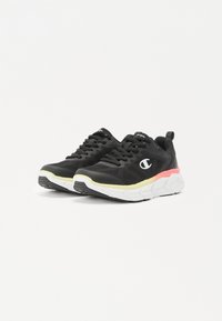 Zwarte sportieve schoenen met een bovenwerk van mesh, vetersluiting, witte zool en roze en gele accenten op de middenzool. Beschikt over een tekstuur op het oppervlak.