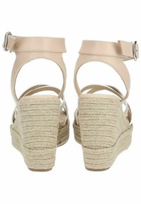 Sandali wedge in pelle nuda con suola in iuta e gomma stile espadrilla, caratterizzati da una cinghia alla caviglia posteriore e un design aperto sul retro.