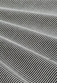 Tkanina w czarno-białe paski o gładkiej fakturze, z falistymi wzorami biegnącymi poziomo przez wiele załamań.