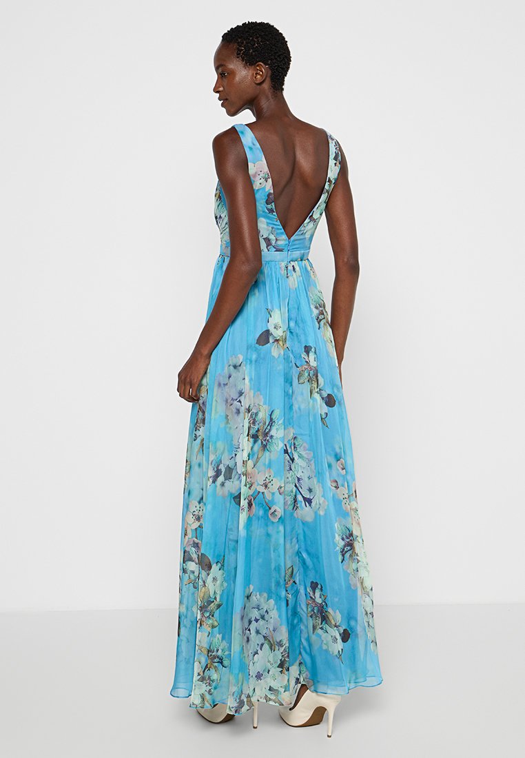 Luftiges blaues Maxikleid mit floralen Mustern, tiefem V-Ausschnitt, ärmellosem Design und weicher Textur. Verfügt über ein enganliegendes Oberteil und florale Muster über das gesamte Kleid.