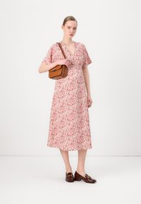 Rochie midi florală cu mâneci scurte, în nuanțe de roz și crem; asortată cu o geantă de umăr maro și loafers maro cu detalii aurii.