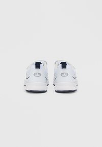 Λευκά και γκρι αθλητικά παπούτσια με υφή στην επάνω μεριά, σκούρες μπλε λεπτομέρειες και επενδεδυμένο κολάρο. Περιλαμβάνουν λογότυπο στη φτέρνα και επίπεδη σόλα.