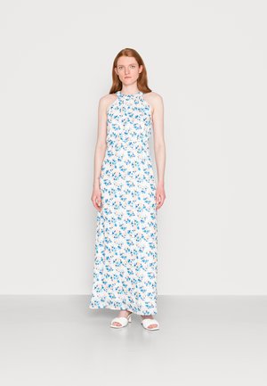 Vestido maxi floral em branco com padrões de flores azuis e pêssego, design de gola halter, tecido fluido e ajuste solto. Apresenta sandálias brancas de deslizar.