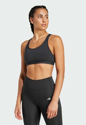 Čierny športový crop top s okrúhlym výstrihom, širokými ramienkami a hladkou textúrou, v kombinácii s čiernymi legínami s vysokým pásom a logom.