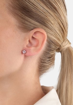 Orecchini a bottone in oro rosa con design circolare, caratterizzati da gemme trasparenti circondate da piccole pietre incastonate, fissati con una chiusura a perno.