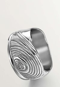 Anillo de plata con superficie texturizada que presenta patrones en espiral y en capas; interior liso y un diseño ancho y curvado.