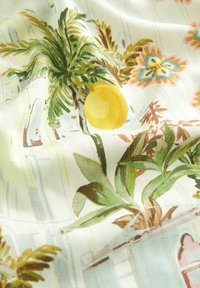Květinová látka se vzorem palmových listů, žlutých citronů, růžových a modrých květin, na světlém pozadí s texturovanými pruhy a jemným leskem.