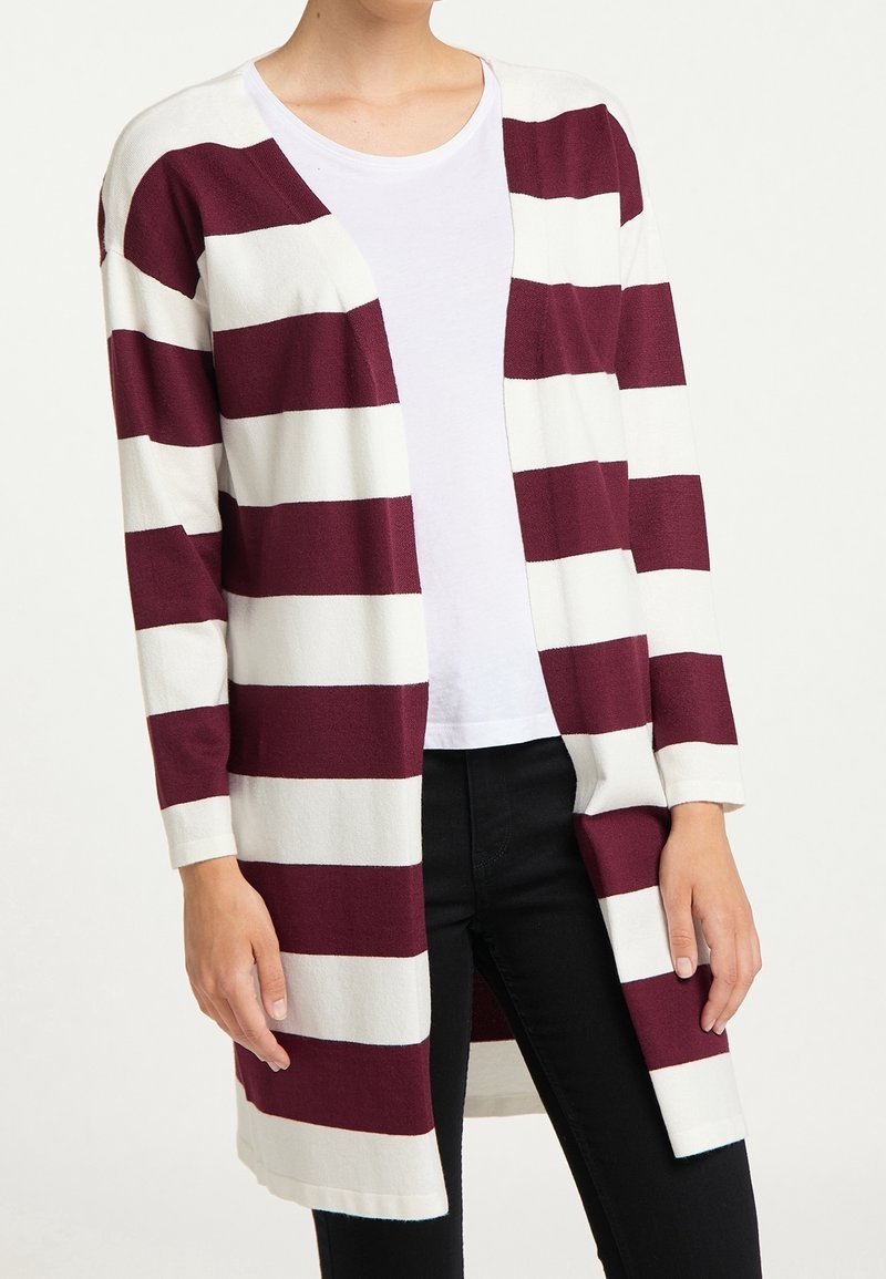 Maroon and white striped cardigan with long sleeves, open front, and a slightly textured fabric. Paired with a white T-shirt and black pants.