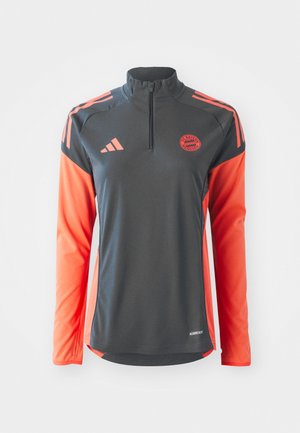 Tennis-Shirt mit Viertelreißverschluss und langen Ärmeln, dunkelgrauer Körper, leuchtend orangefarbene Ärmel, Adidas-Logo und Bayern München-Emblem. Hergestellt aus leichtem Stoff.