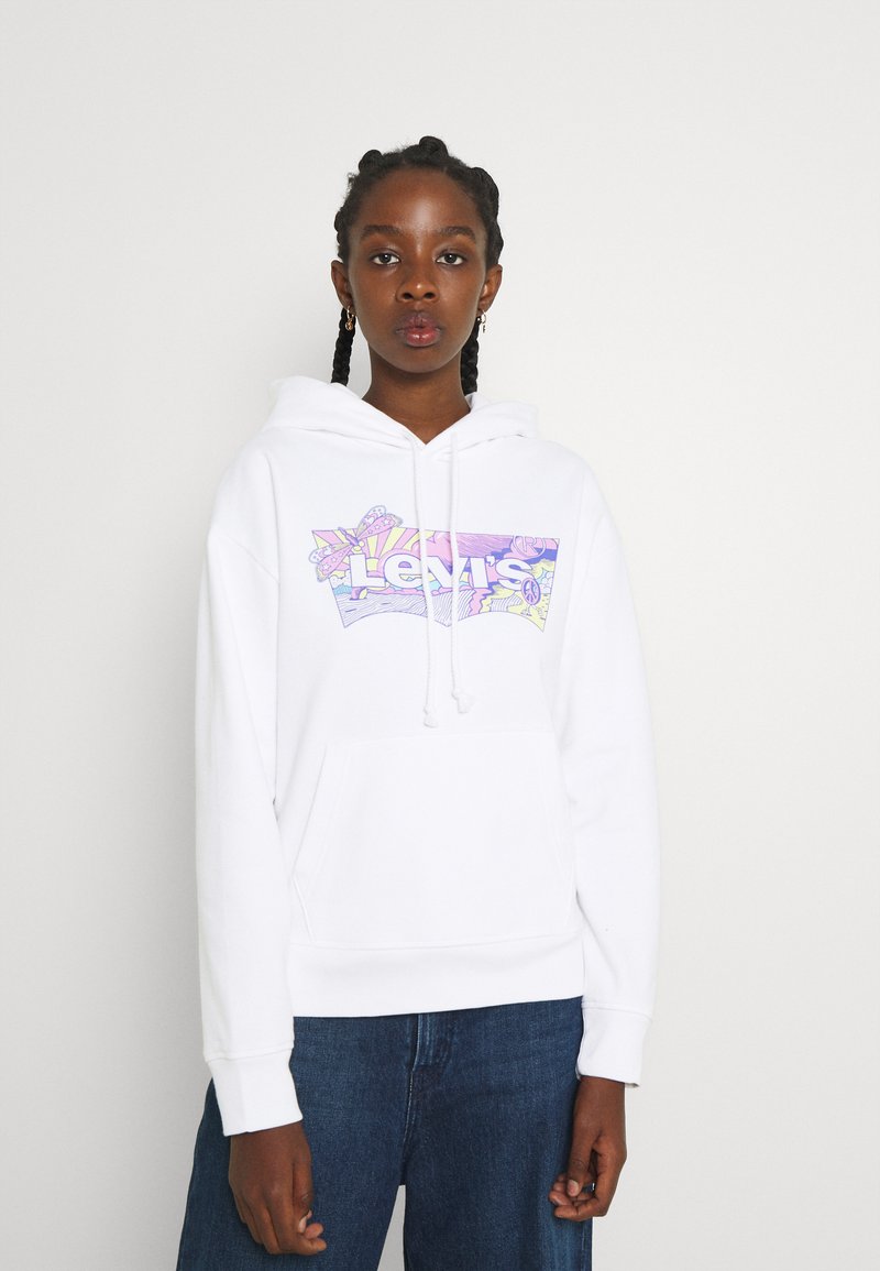 Hvit hettegenser med et frontgrafikk som har "Levi's" i fargerike design. Den har kengurulomme, snor i hetten og ribbede ermer.