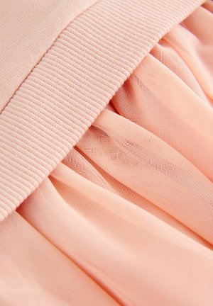 Tissu superposé rose avec une ceinture élastique côtelée et une texture de tulle doux et transparent, offrant une tombée fluide.