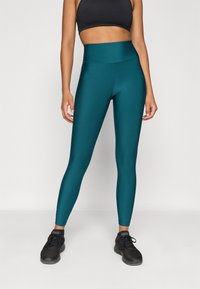 Τεραπευτικά κολάν υψηλής μέσης σε teal από απαλό, ελαστικό ύφασμα, με εφαρμοστή σχεδίαση και χωρίς ορατά μοτίβα ή διακοσμήσεις.